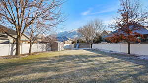 View of yard with a mountain view and a swing set and shed