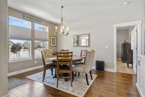 Dining space with a chandelier and dark hardwood / wood-style floors