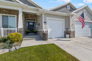 View of exterior entry with covered porch and a garage