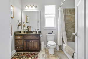 Full bathroom featuring shower / bath combo, vanity, and toilet