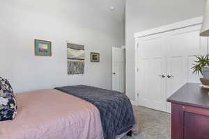 Bedroom featuring light carpet and a closet