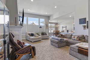 Living room with a chandelier, light colored carpet, and sink