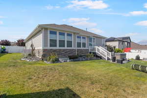 Rear view of house with a yard and a hot tub