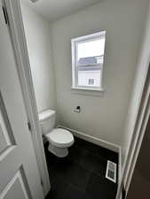 Bathroom with toilet and tile patterned floors