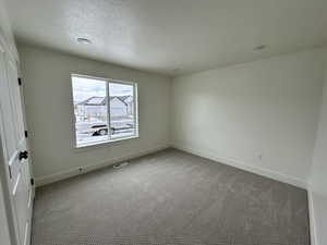 Interior space featuring a textured ceiling and light carpet