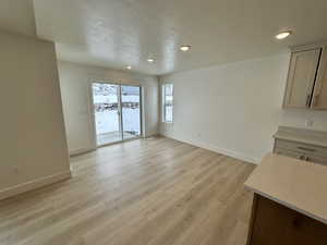 Unfurnished dining area with a textured ceiling and light hardwood / wood-style flooring