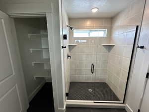 Bathroom with a textured ceiling and walk in shower