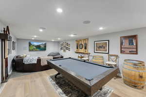 Playroom with light wood-type flooring and billiards