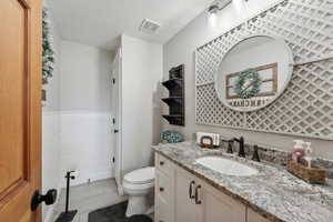 Bathroom with tile patterned flooring, vanity, a textured ceiling, and toilet