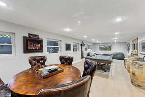 Dining area featuring light hardwood / wood-style floors, a textured ceiling, and billiards