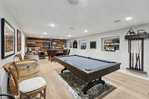 Playroom with wood walls, billiards, and light hardwood / wood-style flooring