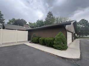 View of property exterior with a garage and parking space (included)