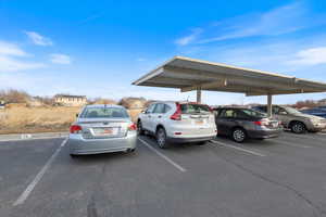 View of parking / parking lot featuring a carport