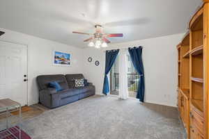 Living room with carpet flooring and ceiling fan