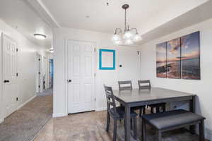 Dining space with carpet floors and an inviting chandelier