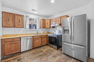 Kitchen featuring dark hardwood / wood-style floors, sink, and appliances with stainless steel finishes