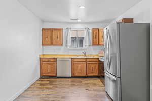 Kitchen featuring sink, light hardwood / wood-style flooring, and appliances with stainless steel finishes