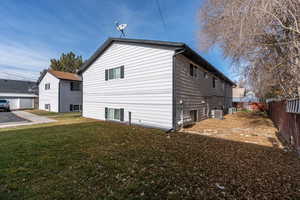 View of home's exterior with a yard and cooling unit