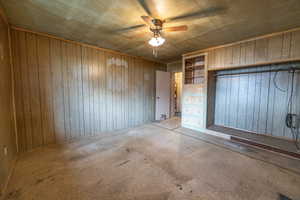 Bedroom #1 featuring ceiling fan and wooden walls