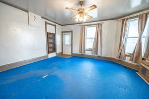 Spare room with ceiling fan and ornamental molding