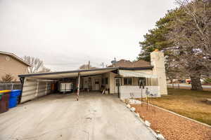 View of front of home with a carport and a front yard