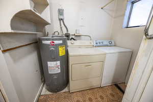 Washroom with washer and clothes dryer and electric water heater, in bathroom