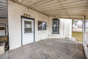 View of exterior entry with a patio area