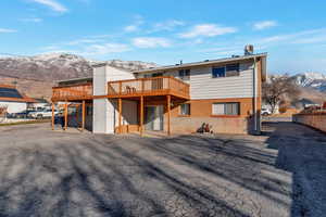 Back of property featuring a deck with mountain view