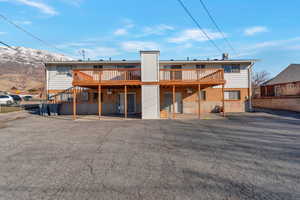 Back of house featuring a deck with mountain view and a patio