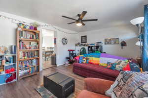 Living room with ceiling fan and dark hardwood / wood-style floors