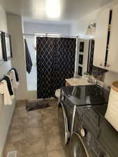 Bathroom featuring tile patterned flooring, sink, and independent washer and dryer