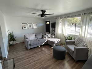 Living room featuring dark hardwood / wood-style floors and ceiling fan