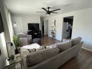 Living room featuring dark hardwood / wood-style floors and ceiling fan