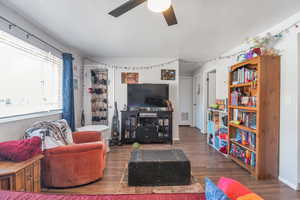 Living room featuring ceiling fan and dark hardwood / wood-style flooring