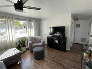 Living room with dark hardwood / wood-style floors and ceiling fan