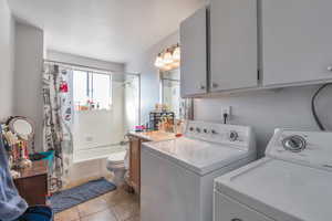 Laundry area with light tile patterned floors and washer and dryer