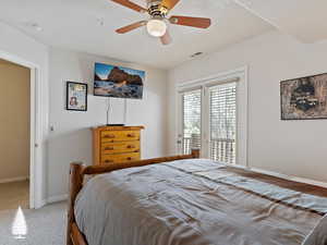 Bedroom with ceiling fan, access to exterior, and carpet floors