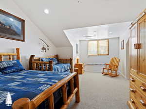 Carpeted bedroom featuring vaulted ceiling