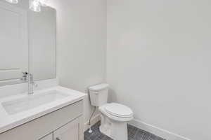 Bathroom featuring tile patterned floors, vanity, and toilet