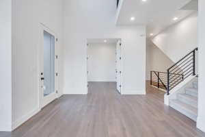 Entrance foyer featuring vaulted ceiling and light hardwood / wood-style flooring