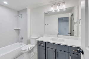 Full bathroom featuring tile patterned floors, tiled shower / bath combo, toilet, and vanity