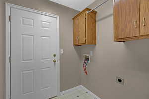 Washroom featuring hookup for an electric dryer, washer hookup, and cabinets