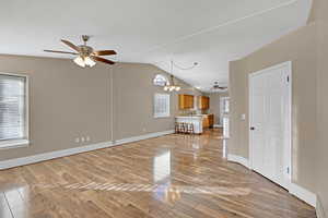 Living room laminate wood-style floors, lofted ceiling, and an inviting chandelier