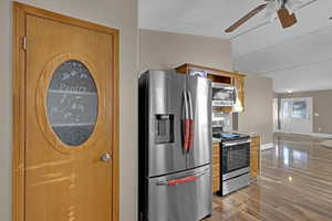 Kitchen featuring appliances with stainless steel finishes, light hardwood / laminate flooring, and pantry