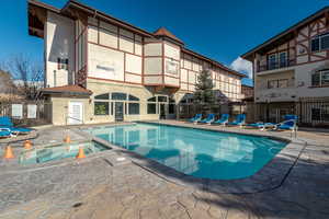View of swimming pool with a patio area and a hot tub