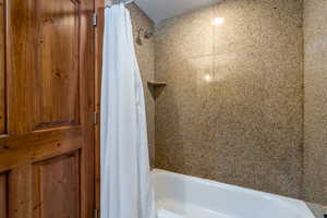 Bathroom featuring shower / bathtub combination with curtain