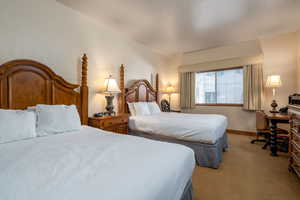 Bedroom featuring light colored carpet and lofted ceiling