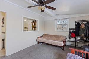 Sitting room featuring carpet flooring, a textured ceiling, vaulted ceiling with beams, and ceiling fan