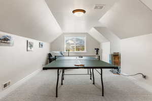 Rec room featuring carpet flooring and vaulted ceiling