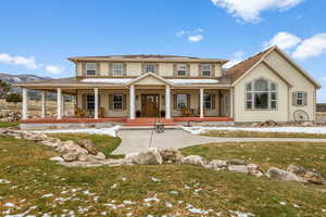 View of front of house with a front lawn and covered porch